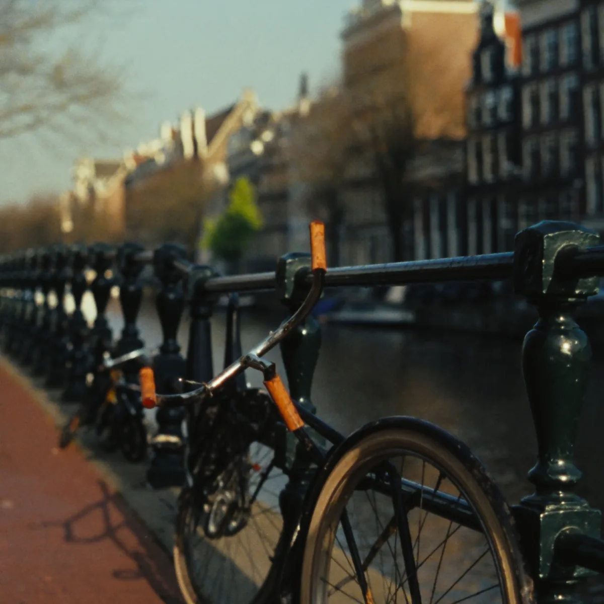Fietsen tegen de leuning van een Amsterdamse grachtbrug